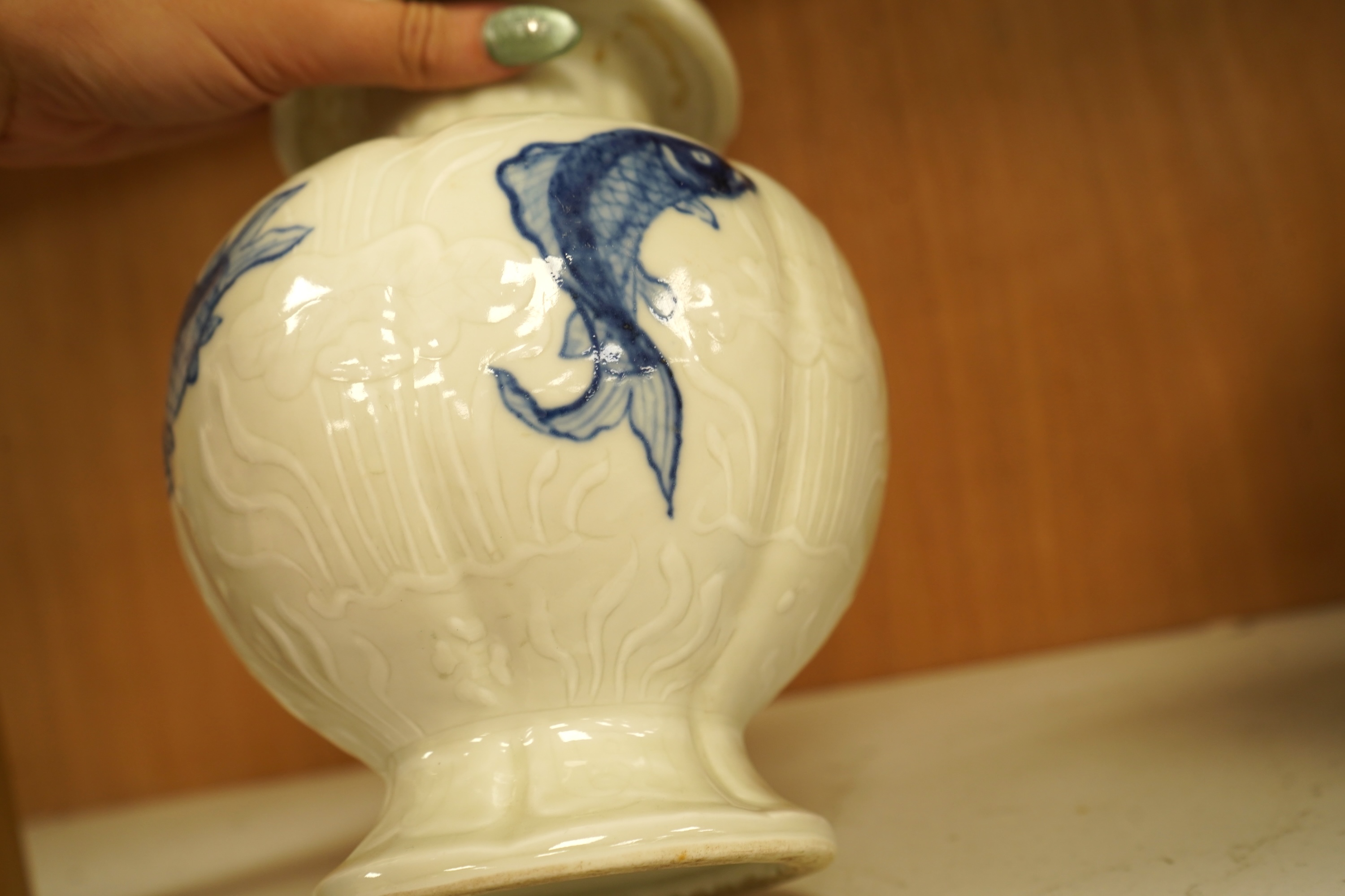 A Chinese vase decorated in low relief, hand painted with fish, 20cm high